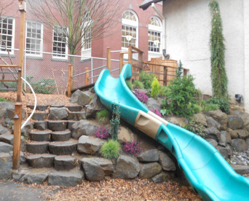 preschool natural playground boulders and slide